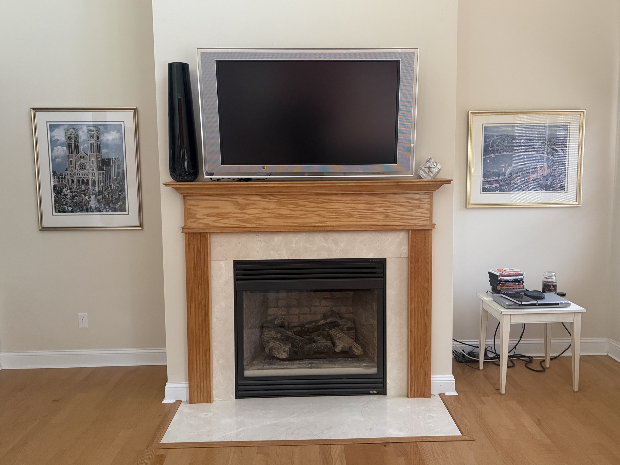 Fireplace wall in a Narragansett, RI home before built-ins, showing an oak mantle with empty wall space on both sides