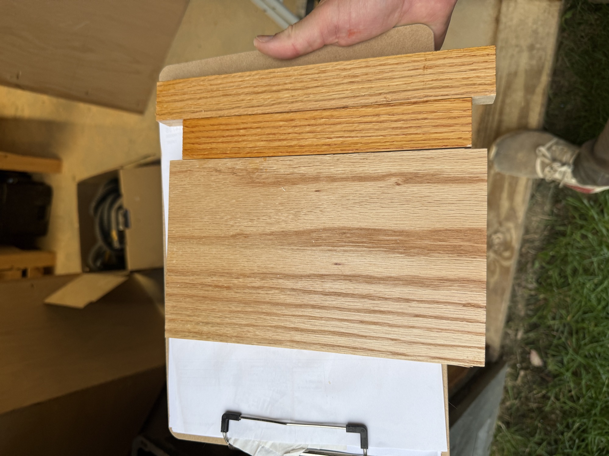 Oak finish test pieces on a clipboard showing different shellac and dye combinations next to bare oak