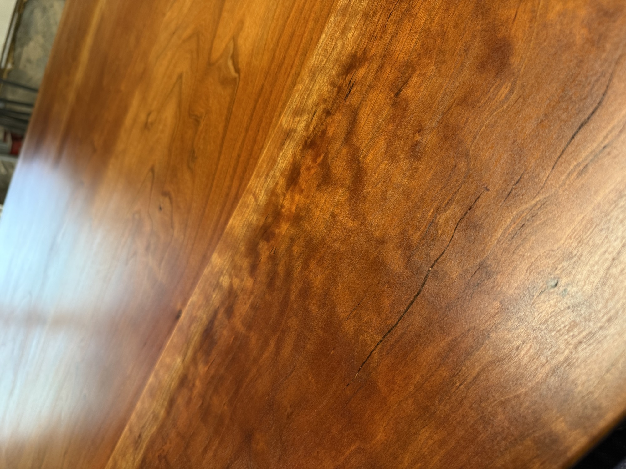 Close-up of figured grain across the boards of a refinished hardwood dining tabletop
