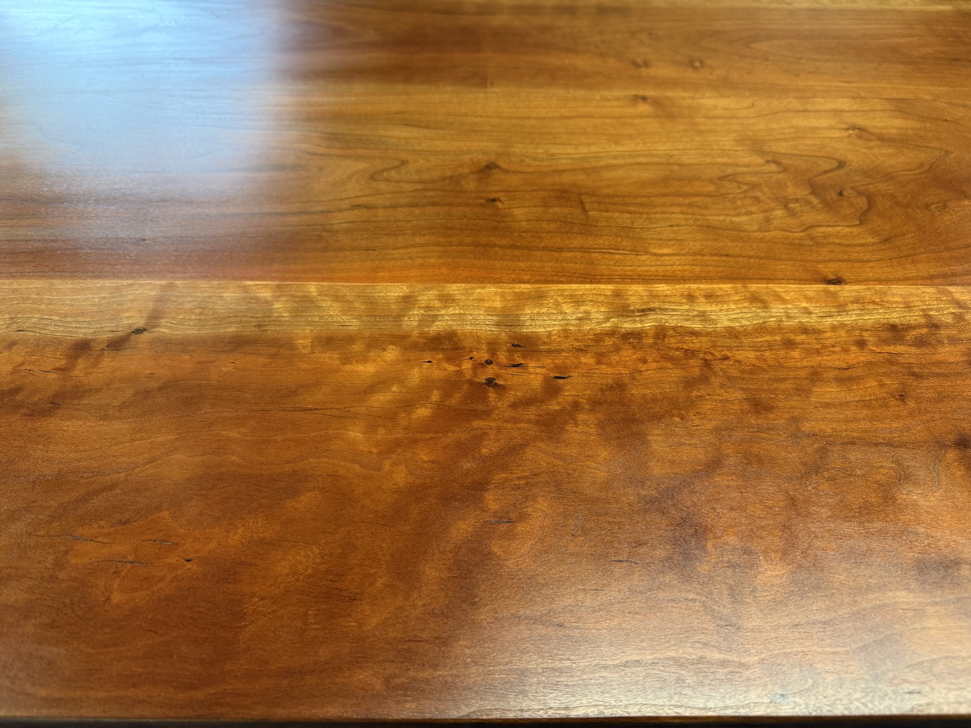 The same section of the Wakefield dining tabletop after refinishing, with an even finish and the grain figure showing through
