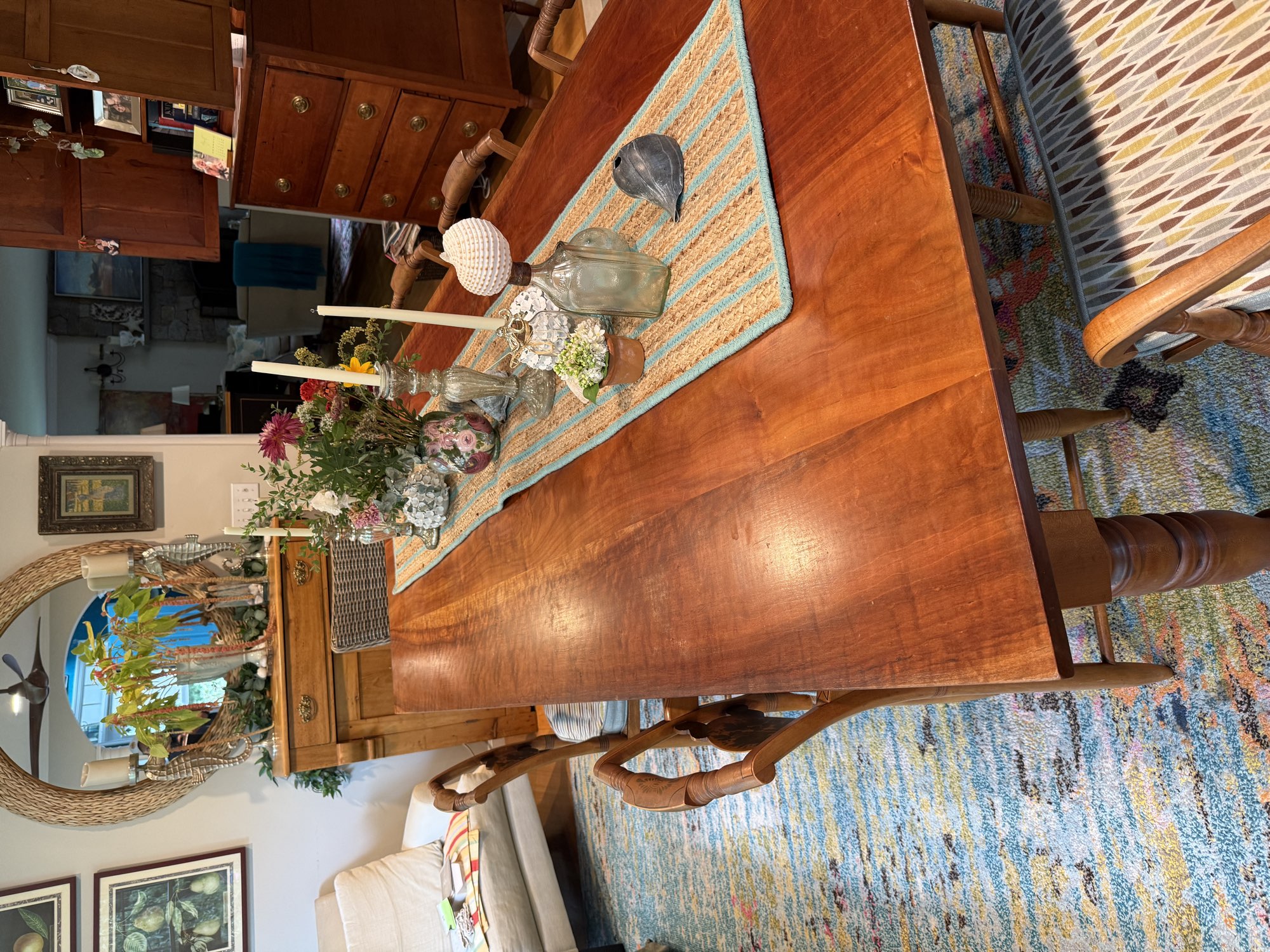 Hardwood dining table set with a runner and centerpiece in a Wakefield, RI dining room before refinishing